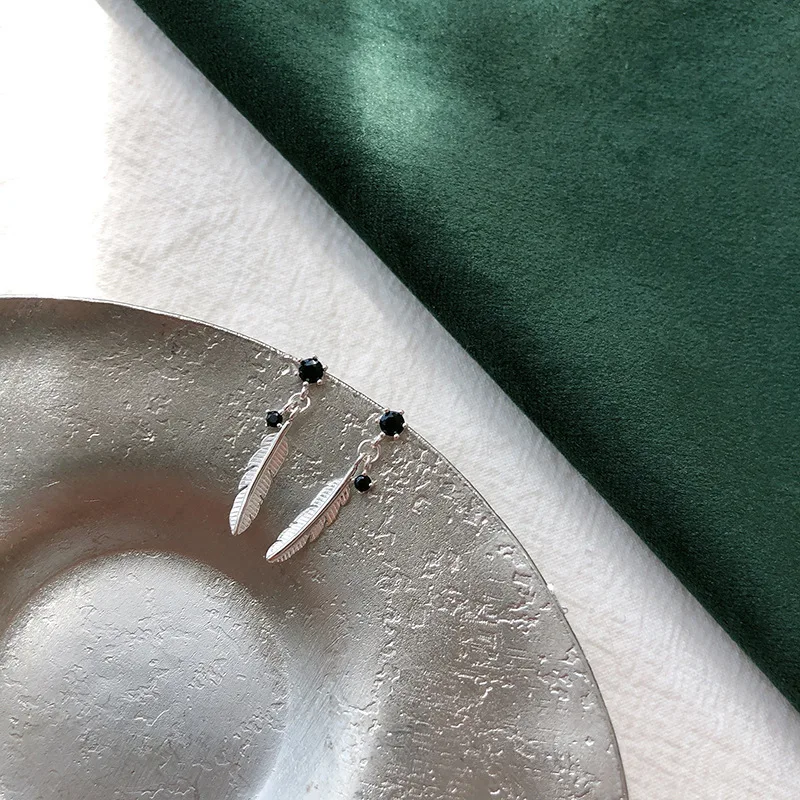 Srebrne asymetryczne kolczyki z piórkiem i kamieniem księżycowym Biały